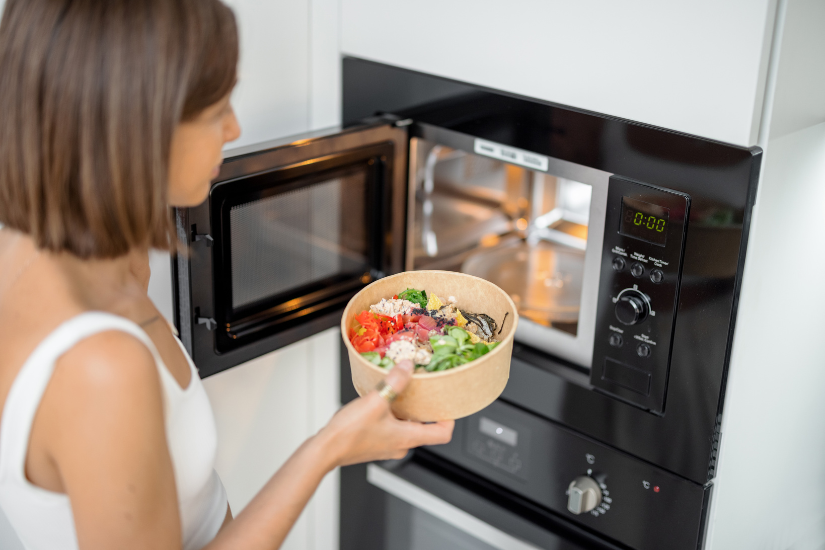 Woman Heating Food in the Microwave